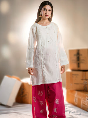 Woman wearing a white kurta with red pants in a neutral setting